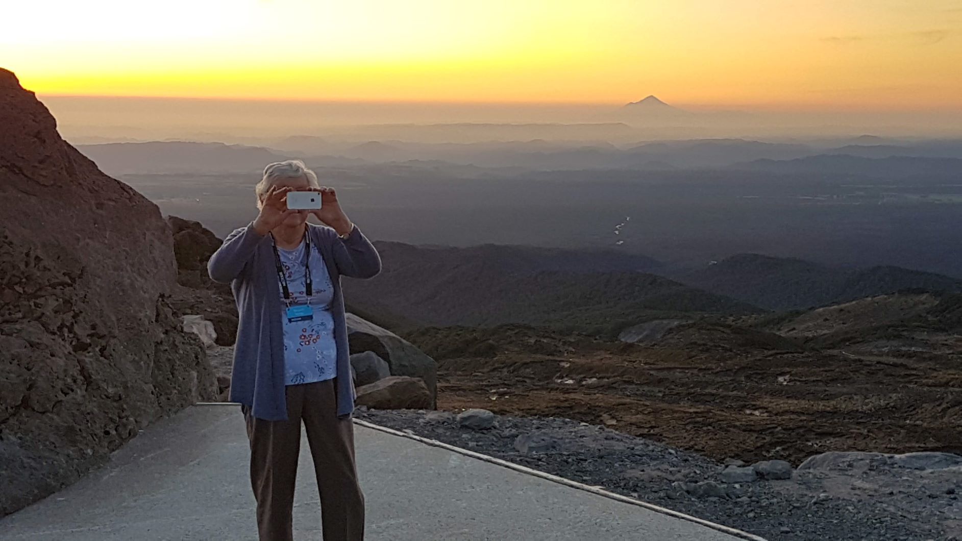 Margaret getting to grips with a selfie and impressive smokey sunset via Australia, Mount Taranaki in the background